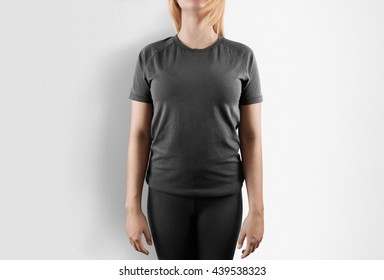 Blank Grey T-shirt Design Mockup. Women Stand Near Wall In Gray Tshirt Clear Template Front Mock Up. Empty Female Apparel Uniform Singlet Model. Sweat Tee Shirt Plain Dress Surface Ready For Print.