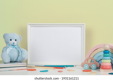 Blank Horizontal Frame Mockup, Baby Room Art, White Wood Blank Frame With Baby Kid Toys On White Desk. Mock Up For Nursery Print, Artwork, Photo