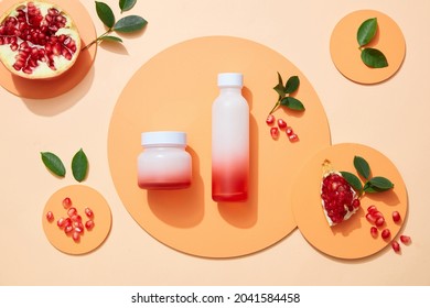 Blank lable Cosmetic set for skin care with pomegranate extract. Whole pomegranate and pomegranate seeds, leaves on podium circle on color background. Topview
				
