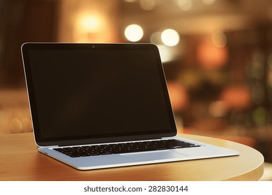 blank laptop in a cafe at evening