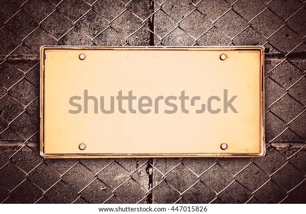 blank license plate with block wall and net\
fence background