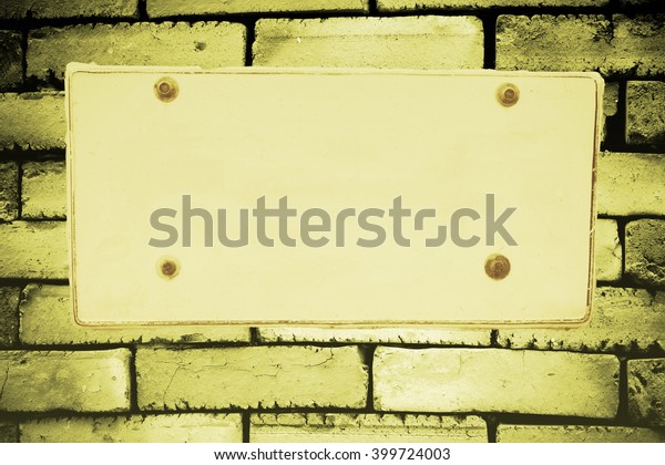 blank license plate on\
stone  wall.