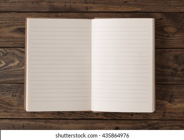 A Blank, Lined Writers Journal Laid Open On A Wooden Desk Top Background