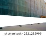 Blank long white hoarding with space for mockup information located in front of construction site with closed scaffold
