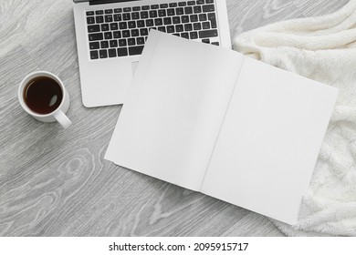 Blank magazine with laptop on light wooden background