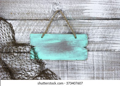 Blank Mint Green Wood Sign With Fish Net Border Hanging On Antique Rustic White Wooden Background