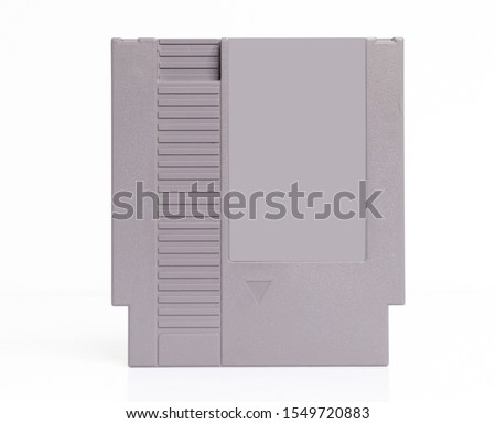 A blank for mockup retro vintage nintendo entertainment system NES console game cartridge isolated on a white background. iconic 1980s video game history and collectables.