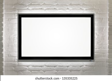 Blank Modern Flat Screen TV At The White Brick Wall With Copy Space