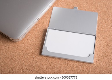 Blank Name Card In Case With Computer On Wooden Table