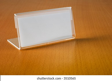 Blank Nameplate On Beech Wood Desk, Reflecting Slightly.