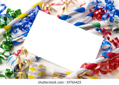 A blank note card surrounded by ribbons, streamers and party noise makers.  New Years eve or birthday party theme
