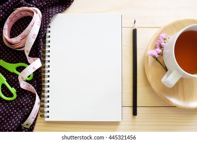 Blank Note Notebook With Sewing Tool And Tea Cup On Wooden Desk