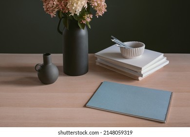 Blank Note Pad, Books, Sprig Of Hydrangea In Stylish Ceramic Vase On Home Office Desk. Mock Up, Copy Space.