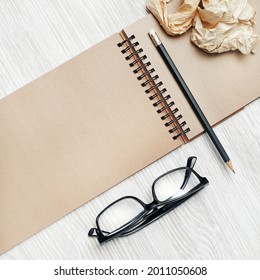 Blank notebook glasses, pencil and crumpled paper. Responsive design mockup. Stationery set. Template for placing your design. Top view. Flat lay. - Shutterstock ID 2011050608