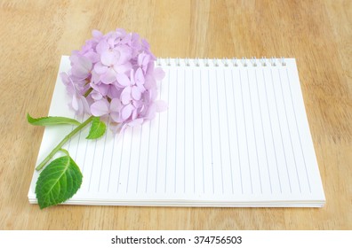 Blank notebook with Hydrangea flower on wooden table