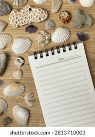 A blank notebook with notepad space is nestled among seashells, coral, and decorative stones. Concept for vacation planning, travel, summer vacations, inspiration, and copy space.