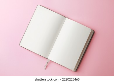 Blank notebook on pale pink background, top view