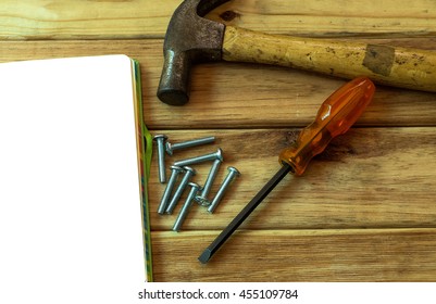 A blank notebook and set of manual tools on grunge wood background, copy-space.
