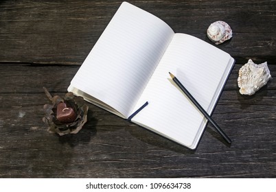Blank Notebook and shells on a rustic wood table