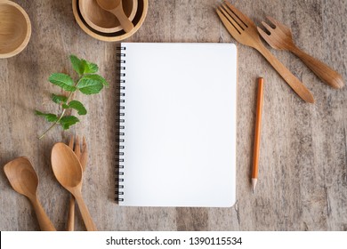 Blank notebook for text note on wooden table background. On wooden have spoon fork and pencil - Powered by Shutterstock