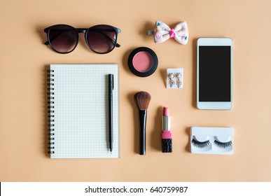 Blank notebook with Various makeup products and smart phone on color background, Top view
