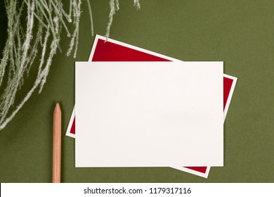Blank notecard and pencil on green background
