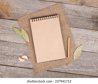 Blank notepad for copy space and herbs on wooden table