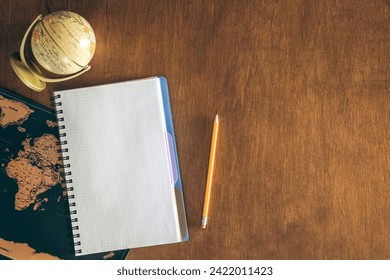 Blank notepad, globe and map on a wooden table, top view. - Powered by Shutterstock