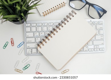 Blank notepad on keyboard computer. Paper note empty space for record information at workplace. copyspace.