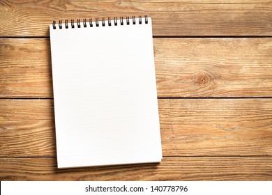 Blank notepad on a wooden surface. - Shutterstock ID 140778796