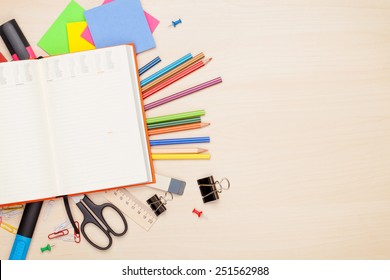 Blank Notepad Over School And Office Supplies On Office Table. Top View With Copy Space