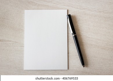 Blank Notepad And Pen On Wooden Table