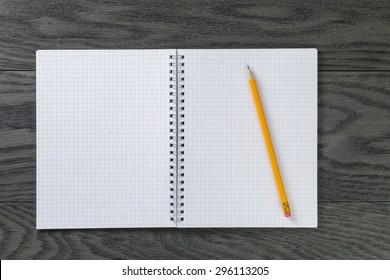 blank notepad with pencil on gray wood table, top view