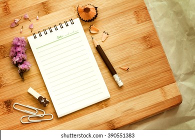 Blank notepad with  pencil on wooden table , overhead shot or Top view