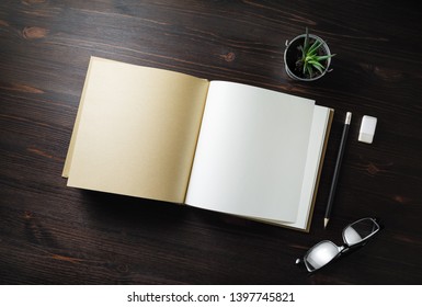 Blank Open Book, Stationery And Plant On Light Wooden Background. Flat Lay.