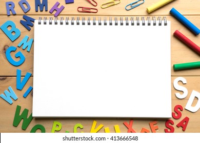 Blank open notebook with numbers and English alphabets on wooden background ready for text
