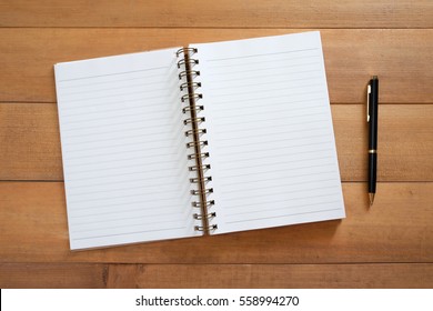 Blank Open Notebook With Pen On Wooden Desk