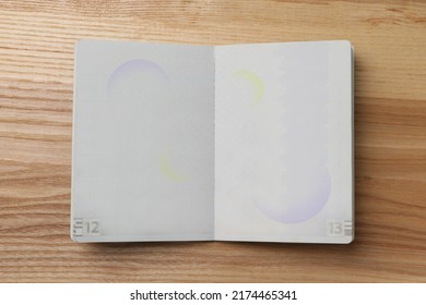 Blank open passport on wooden table, top view