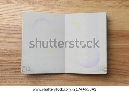 Blank open passport on wooden table, top view