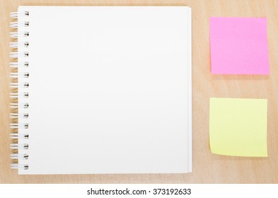 Blank opened notebook on table. Office table with notepad, post it note, Writing concept. View from above with copy space