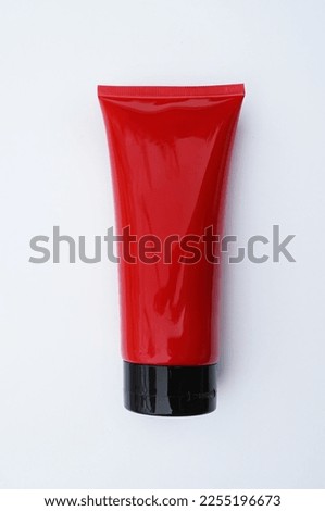                                blank packaging crimson red cosmetic plastic tube isolated on white background with clipping path ready for product design