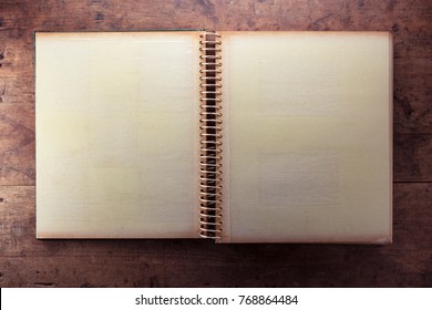 Blank Page Of An 1970s Photo Album, In Retro Tone, On A Dark Well Used Rustic Wooden Table. 