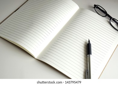blank page notebook paper with pen and glasses - Shutterstock ID 143795479