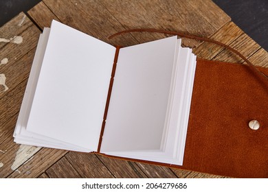 Blank Pages Of Open Journal With Brown Leather On Wood Planks