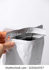 A blank paper bag with a zip lock is holding the package hand. - Shutterstock ID 2154161917
