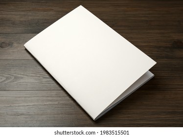 Blank Paper Brochure On Wooden Table. Mockup For Design