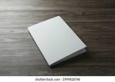 Blank Paper Brochure On Wooden Table. Mockup For Design