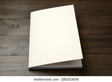 Blank Paper Brochure On Wooden Table. Mockup For Design