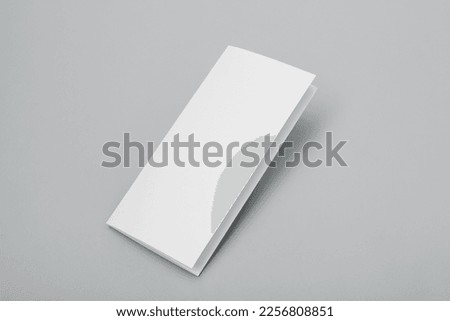 Blank paper folded on gray background
