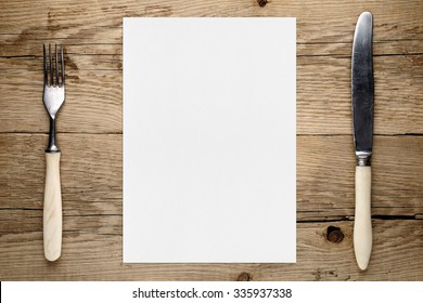 Blank Paper For Menu And Fork And Knife On Wooden Table